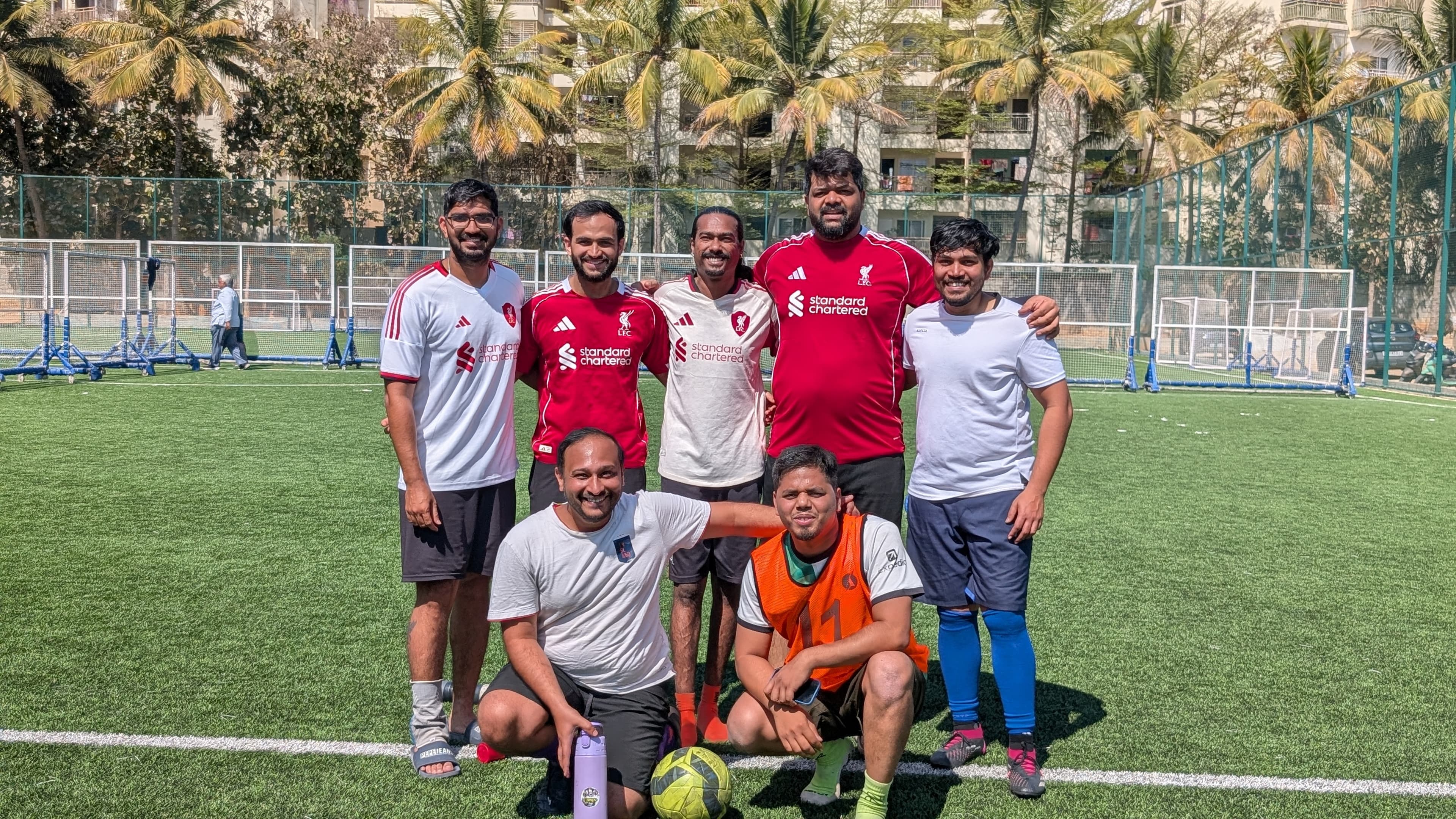 A group of players posing together after a game on a football turf at 3lok Football Fitness Hub, Bengaluru